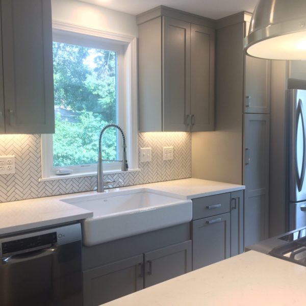 View of kitchen sink, window, and cabinets.