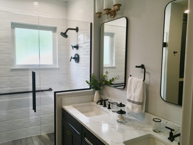 Part of a bathroom, showing the double vanity and glassed-in shower