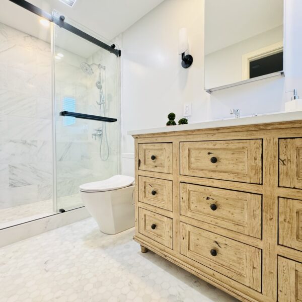 Bathroom, with a glassed-in shower, toilet, and vanity.