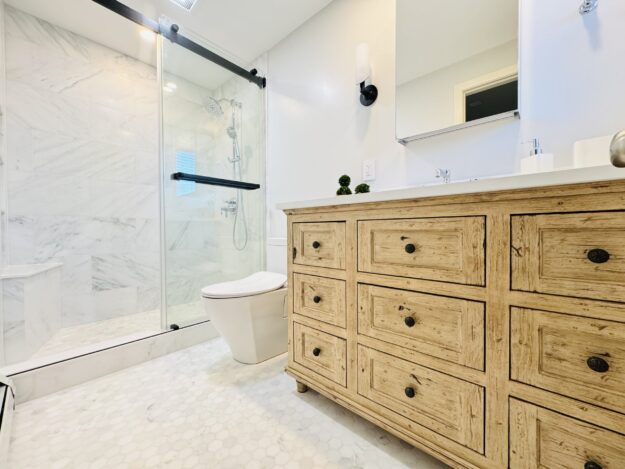 Bathroom, with a glassed-in shower, toilet, and vanity.